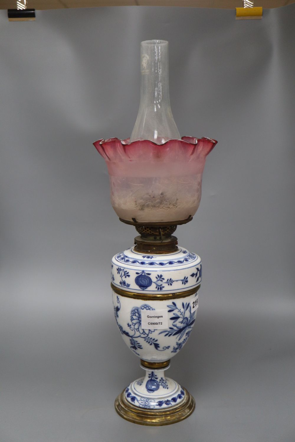 A Meissen onion pattern oil lamp, with cranberry shade